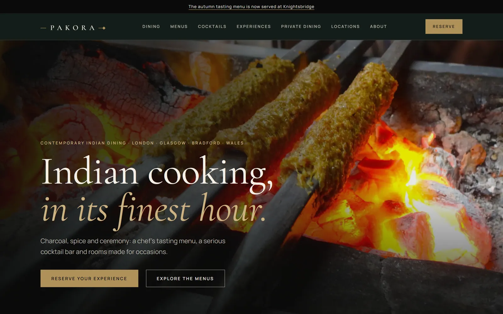 PAKORA homepage hero: seekh kebabs over charcoal with the line Indian cooking, in its finest hour